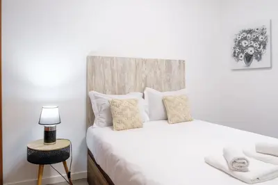 a bedroom with a white bed with a wooden headboard at GuestReady - Charming stay with beautiful views in Santa Cruz
