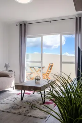 a living room with a chair and a table and a window at GuestReady - Charming stay with beautiful views in Santa Cruz