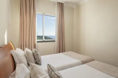 a hotel room with two beds and a window at Pico Views by An Island Apart in Câmara de Lobos