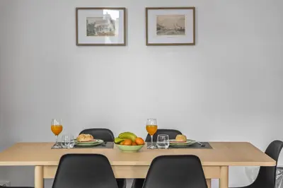 a table with a bowl of fruit and two glasses of wine at Reis by KAAMAH in Ribeira Brava