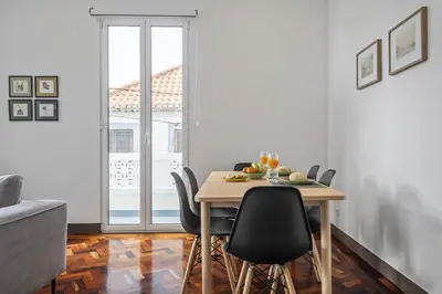 a dining room with a table and chairs and a window at Reis by KAAMAH in Ribeira Brava