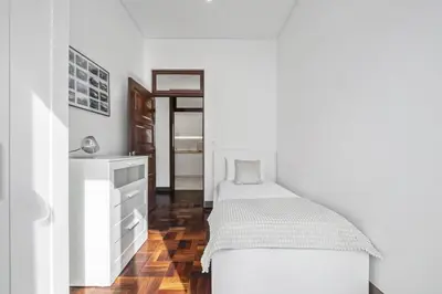 a white bedroom with a bed and a dresser at Reis by KAAMAH in Ribeira Brava