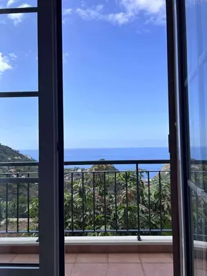 a balcony with a table and a view of a mountain at Casa Tabua in Ribeira Brava
