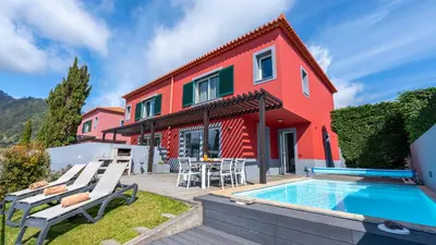 a house with a swimming pool in front of it at DuskLine Villa in Arco da Calheta