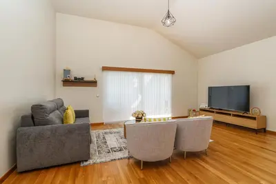 a living room with a couch and a tv at Rosas House, private house with jacuzzi and BBQ in Estreito da Calheta