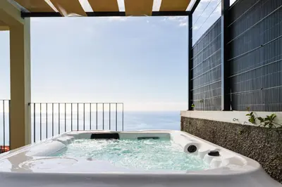a bath tub with a view of the ocean at Rosas House, private house with jacuzzi and BBQ in Estreito da Calheta
