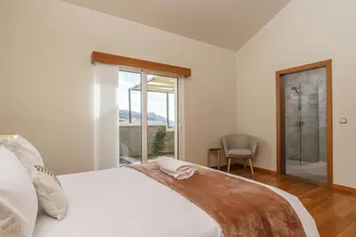 a bedroom with a white bed and a window at Rosas House, private house with jacuzzi and BBQ in Estreito da Calheta