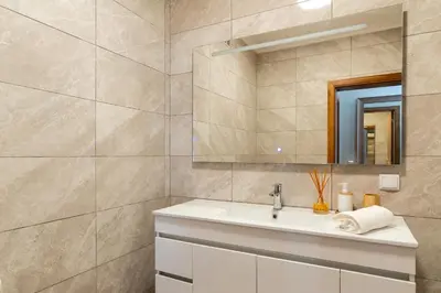 a bathroom with a sink and a mirror at Rosas House, private house with jacuzzi and BBQ in Estreito da Calheta