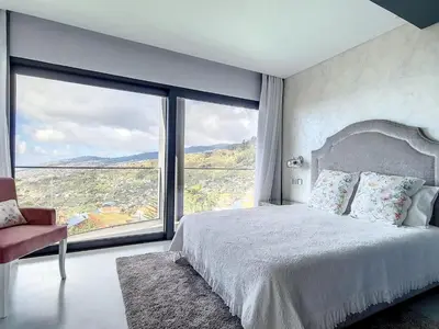 a bedroom with a bed and a large window at Holiday Home VILLA BONSAI by Interhome in Arco da Calheta