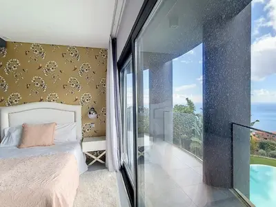 a bedroom with a bed and a view of the ocean at Holiday Home VILLA BONSAI by Interhome in Arco da Calheta