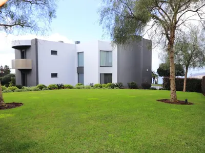 a white building with a green lawn in front of it at Holiday Home VILLA BONSAI by Interhome in Arco da Calheta