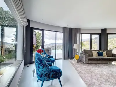 a living room with blue chairs and a couch at Holiday Home VILLA BONSAI by Interhome in Arco da Calheta
