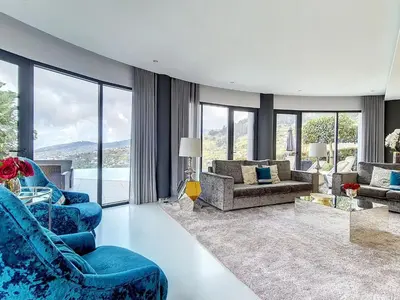 a living room with blue furniture and a large window at Holiday Home VILLA BONSAI by Interhome in Arco da Calheta