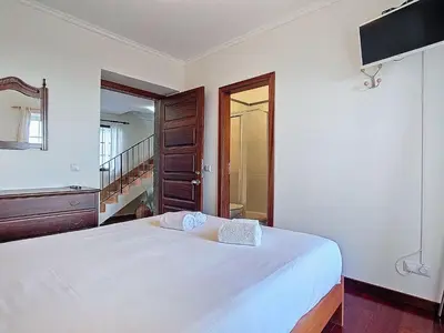a bedroom with a large white bed and a television at Holiday Home Haus Seixal by Interhome in Seixal