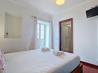 a white bedroom with a bed with towels on it at Holiday Home Haus Seixal by Interhome in Seixal
