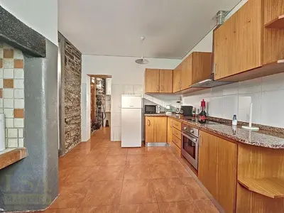 a kitchen with wooden cabinets and a white refrigerator at Holiday Home Quinta do Serrado 2 by Interhome in Ribeira da Janela