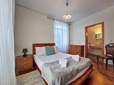 a bedroom with a bed and a chair in it at Holiday Home Quinta do Serrado 2 by Interhome in Ribeira da Janela