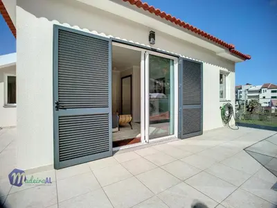 a house with aluminium shutter doors on a patio at Holiday Home PEARLS BEACH VILLA by Interhome in Porto Moniz