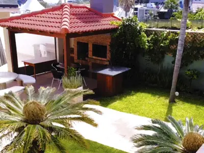 a backyard with a dog house and palm trees at Holiday Home PEARLS BEACH VILLA by Interhome in Porto Moniz