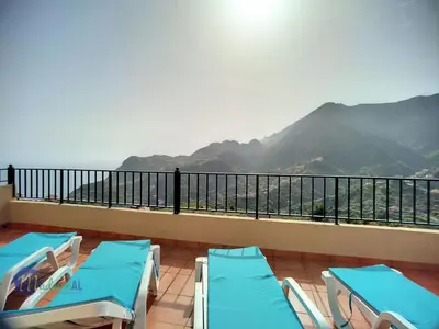 a balcony with blue chairs and a view of mountains at Holiday Home Casa do Romaninho by Interhome in Porto da Cruz