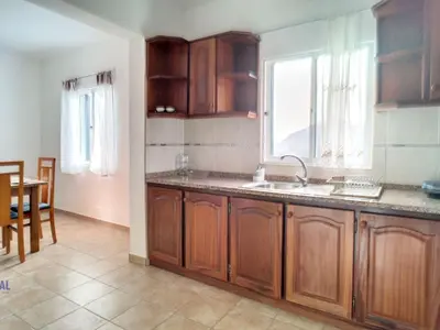 a kitchen with wooden cabinets and a sink and a window at Holiday Home Casa do Romaninho by Interhome in Porto da Cruz