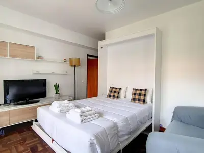 a bedroom with a large white bed and a flat screen tv at Apartment Wohnung in Funchal- in der Nähe von Farmers Market by Interhome in Funchal