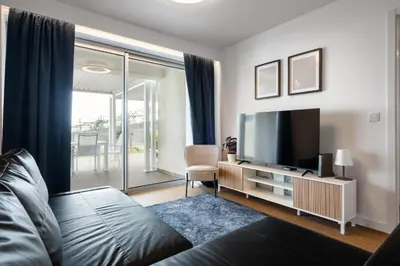 a living room with a tv and a chair at Oceanfront Bliss - Atlantico residences in Câmara de Lobos