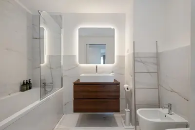 a white bathroom with a sink and a mirror at Oceanfront Bliss - Atlantico residences in Câmara de Lobos