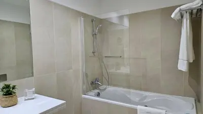 a bathroom with a shower and a tub and a sink at Downtown Funchal Bohemian Charm in Funchal
