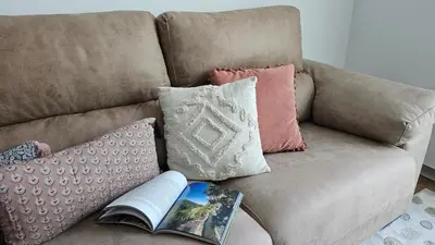 a couch with a book and pillows on it at Downtown Funchal Bohemian Charm in Funchal