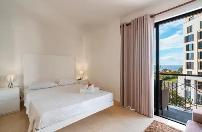 a bedroom with a bed and a large window at Madeira Holidays Studio by Amazing Madeira in Funchal