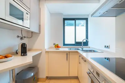 a kitchen with white counters and a sink and a window at Madeira Holidays Studio by Amazing Madeira in Funchal