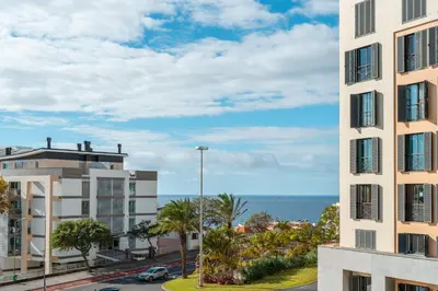 a view of a building with the ocean in the background at Madeira Holidays Studio by Amazing Madeira in Funchal