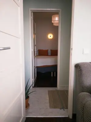 a hallway leading to a bedroom with a bed at Casinha Menta in Carrapateira