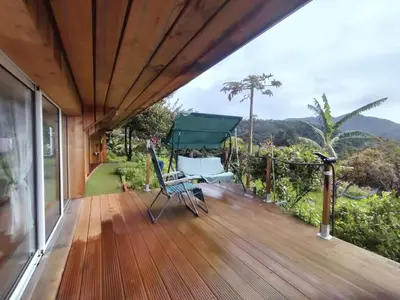 a wooden deck with a view of the mountains at casa do campo in Machico