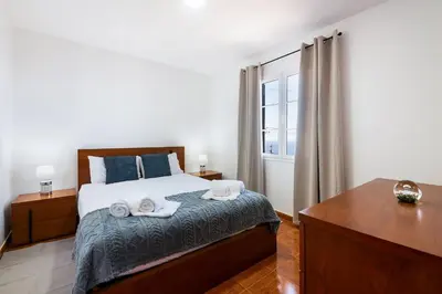 a bedroom with a bed with two towels on it at Villa Jardim by GALMI in São Vicente