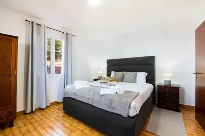 a bedroom with a large bed and a window at Villa Jardim by GALMI in São Vicente