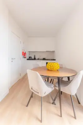 a dining room table with white chairs and a bowl of fruit at Angie's House in Funchal