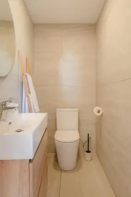 a bathroom with a white toilet and a sink at Angie's House in Funchal