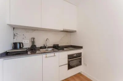 a white kitchen with a sink and a stove at Angie's House in Funchal