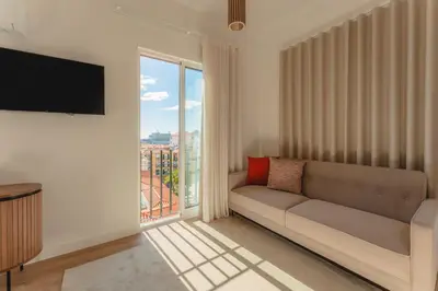 a living room with a couch and a large window at Angie's House in Funchal
