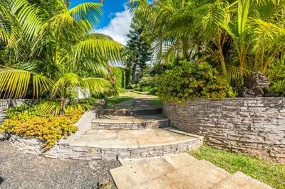a stone pathway with palm trees and a retaining wall at Quintinha de São Martinho - Villa & Lux in Funchal
