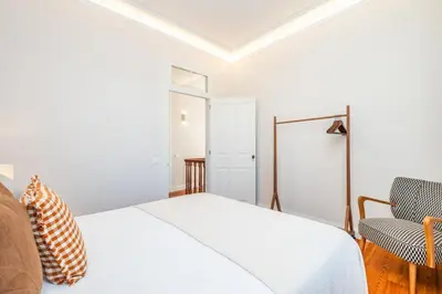 a white bedroom with a bed and a chair at Quintinha de São Martinho - Villa & Lux in Funchal