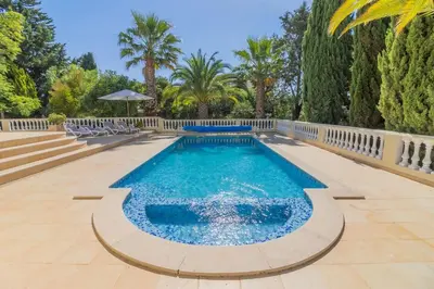 a swimming pool with chairs and trees in a yard at Casa Magnólia in Luz