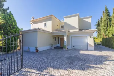 a white house with a gate and a driveway at Casa Magnólia in Luz