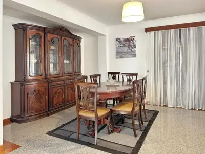 a dining room with a wooden table and chairs at Blue Horizon House in Funchal