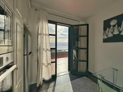 a kitchen with a door to a balcony with the ocean at Blue Horizon House in Funchal