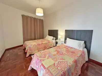 a bedroom with two beds and a lamp at Blue Horizon House in Funchal