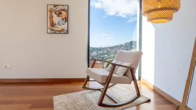 a chair in a room with a large window at Villa Jamboeiro by LovelyStay in Funchal