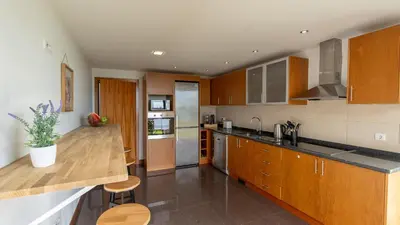 a kitchen with wooden cabinets and a counter top at Villa Jamboeiro by LovelyStay in Funchal